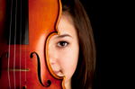 Mädchen schaut hinter einer Geige hervor