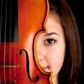 Mädchen schaut hinter einer Geige hervor